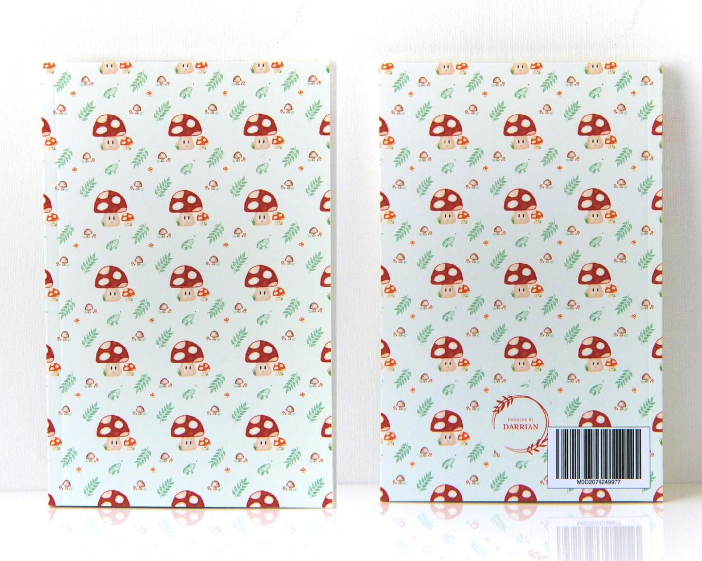Front and back of a warm white notebook with a cover featuring a watercolour mushroom pattern, the pattern includes smiling spotted mushrooms, brown mushrooms, leaves, and small green frogs.