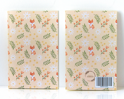 Notebook front and back with cream covers featuring a watercolour pattern with orange foxes, daisies, orange and yellow flowers, and leaves.