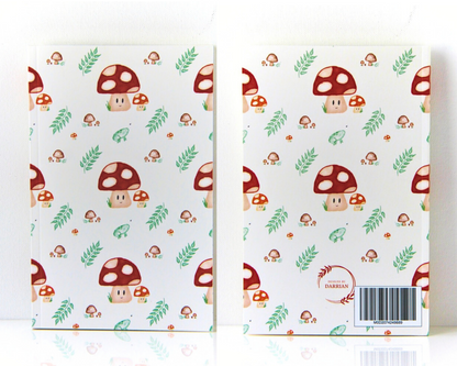 Front and back of a warm white notebook with a cover featuring a watercolour mushroom pattern, the pattern includes smiling spotted mushrooms, brown mushrooms, leaves, and small green frogs. 