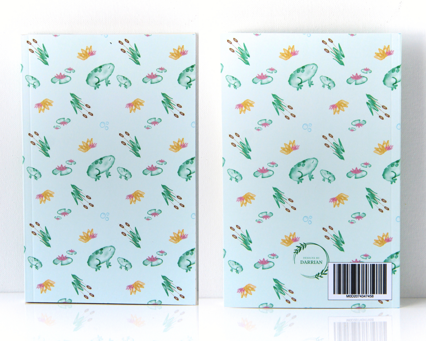 Pastel Green Notebook with a cover featuring green watercolour frogs, cattails, lily pads, and orange and pink lotus flowers